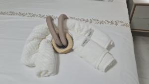a white bed with two towels and two slippers at Casa da Miss in Florianópolis +8 photos