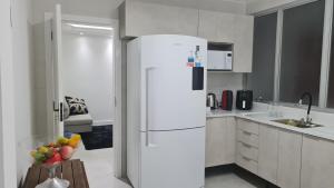 a white kitchen with a white refrigerator in it at Casa da Miss in Florianópolis