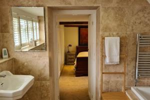 a bathroom with a sink and a mirror and a bed at Wellow Farmhouse in Wellow +40 photos