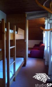 a room with two bunk beds and a couch at Villaggio turistico ploner appartaments in Carbonin