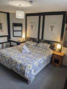 a bedroom with a large bed with flowers on it at Prestleigh Inn in Shepton Mallet +15 photos