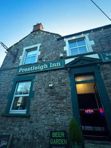a brick building with a sign for a beer garden at Prestleigh Inn in Shepton Mallet
