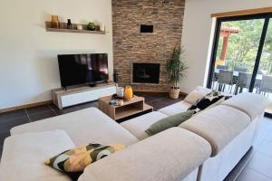 a living room with two white couches and a television at Casa Picone - Gerês in Ventosa