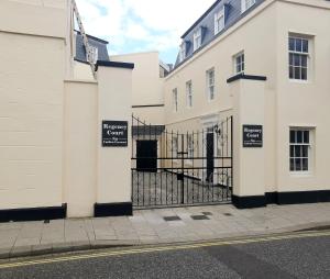 a row of white buildings with a gate at Courtyard Retreat in Southampton