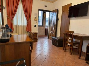 a living room with a table and a kitchen with a television at EURO HOUSE INN airport in Fiumicino