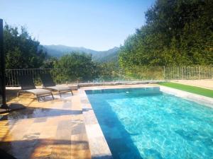 a large swimming pool with two chairs next to it at Casa Picone - Gerês in Ventosa