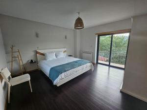 a bedroom with a bed and a large window at Casa Picone - Gerês in Ventosa