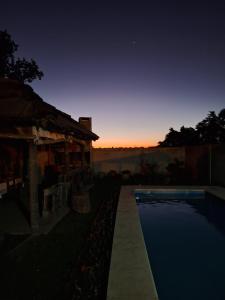 ein Pool vor einem Haus mit Sonnenuntergang in der Unterkunft La Casita de Areco in San Antonio de Areco