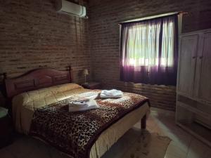 a bedroom with a bed with two towels on it at La Casita de Areco in San Antonio de Areco