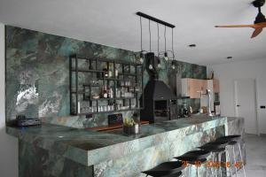 a kitchen with a bar with stools in it at Entre Olivos in Níjar