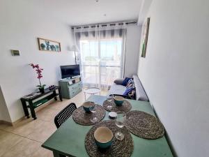 a living room with a table with plates on it at Apartment Sotavento by Interhome in Los Amarguillos