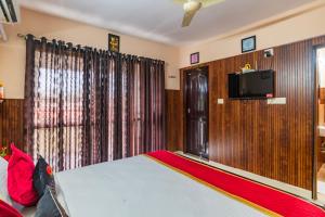 a bedroom with a bed and a flat screen tv at Mayflower Airport Launge cochin international airport in Nedumbassery +32 photos
