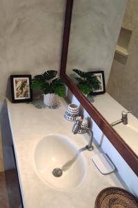 グアジルにあるVila Carnaúba - casa pé na areia em Guajiru Trairiのバスルーム(鏡、植物2本付)