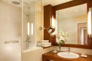 a bathroom with a sink and a shower and a mirror at Gradlon in Quimper