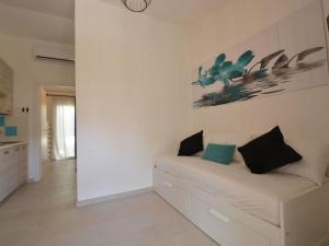 a white living room with a white couch with two pillows at Holiday Home Mirto Marino-2 by Interhome in Costa Rei