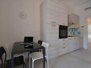 una cucina con un tavolo con un computer portatile sopra di Holiday Home Mirto Marino-9 by Interhome a Costa Rei