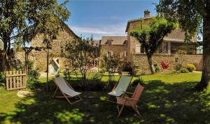 un cortile con due sedie e una casa di Le Clos du Barry a Sévérac-lʼÉglise