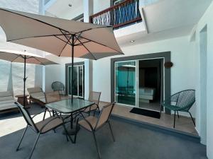 ein Esszimmer mit Tisch und Stühlen und einem Sonnenschirm in der Unterkunft Hotel Caracol Isla Mujeres in Isla Mujeres