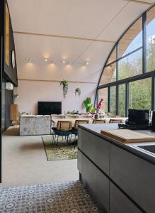 un ampio soggiorno con tavolo e divano di Bosresort Maanzicht a Noordwolde