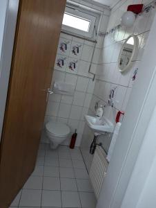 a small bathroom with a toilet and a sink at Gemütliche Wohnung im Retrostil in Nattheim +1 photo