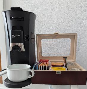 a coffee maker and a cup on a table at Gemütliche Wohnung im Retrostil in Nattheim +1 photo