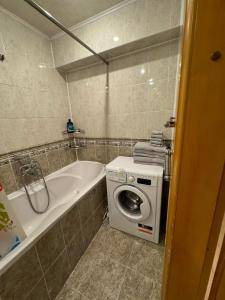 La salle de bains est pourvue d'un lave-linge et d'une baignoire. dans l'établissement Center 2 bedrooms Hajdeu, à Chişinău