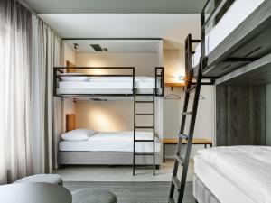 a bunk bed room with two beds and a ladder at H2 Hotel Saarbrücken, Trademark by Wyndham in Saarbrücken