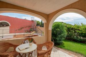a patio with a table and chairs and two windows at Hotel Mariposas in Villasimius