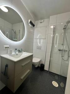 トロムソにあるSentral studioleilighetの洗面台、シャワー、トイレ付きのバスルーム