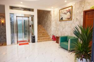 a living room with a green couch and stairs at Kiều Tiên Hotel Long Thành in Long Thành