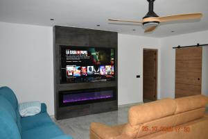 a living room with a couch and a flat screen tv at Entre Olivos in Níjar