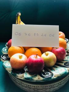 a bowl of apples and oranges with a sign on it at Villa Casa azul in Cuxac-dʼAude