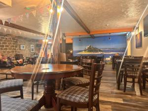 a restaurant with wooden tables and chairs and a large screen at SeaBreeze Lodge, located between Penzance & St Ives - A sanctuary to relax & unwind with activities on the doorstep for all the family in Penzance