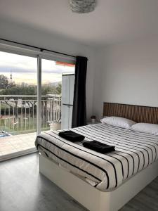 a bedroom with a bed and a large window at Precioso apartamento en la playa Barcelona in Cabrera de Mar