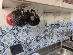 a kitchen with pots and pans hanging from a sink at Colonial Praiano in Guarapari +38 photos