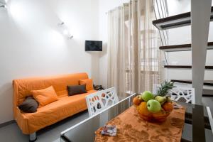 an orange couch in a living room with a table at Quattro Canti Apartments in Palermo