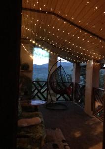 a room with a balcony with a table and lights at Milana Guesthouse in Slavske