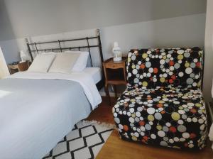 a bedroom with a bed and a chair with polka dots at Les deux sources in Saint-Laurent-en-Royans