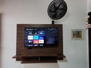 a flat screen tv on a wall with a fan at Colonial Praiano in Guarapari
