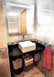 a bathroom with a sink and a mirror and baskets at APPART STANDING 2 chambres 2SDB clim PISCINE PARKING WIFI TERRASSE 21m2 LOCAL VELO Port-Aventura, plage, centre in Salou