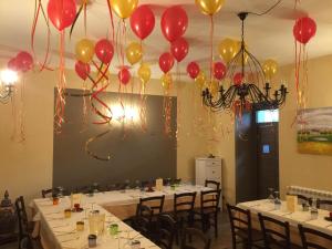 a room with tables with red and yellow balloons at Mama Lina in Patti