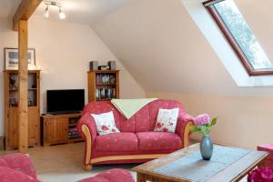 ein Wohnzimmer mit einem roten Sofa und einem Fernseher in der Unterkunft Ferienwohnung Norderwurth in Büsumer Deichhausen