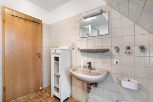 ein Badezimmer mit Waschbecken und Spiegel in der Unterkunft Ferienwohnung Norderwurth in Büsumer Deichhausen + 15 Fotos