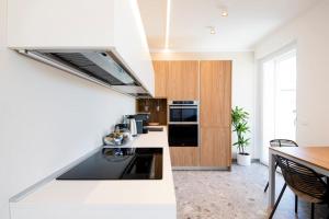 a kitchen with white counters and a black appliances at Luxury House - Small Heated Pool in Bardolino +13 photos