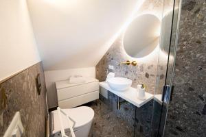 a bathroom with a sink and a toilet and a mirror at Luxury House - Small Heated Pool in Bardolino