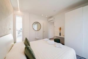 a white bedroom with a large bed and a mirror at Luxury House - Small Heated Pool in Bardolino
