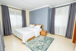 a bedroom with a white bed and a blue wall at Cedar Calm in Kigali
