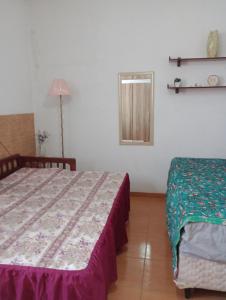 a bedroom with a bed and a mirror on the wall at Casa de praia Pitória São Pedro da Aldeia in São Pedro da Aldeia