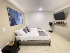 a bedroom with a bed and a flat screen tv at Castellana 201-Apartaestudio en la Castellana con espacio trabajo in Armenia