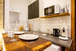 a kitchen with a counter top with two white plates on it at Le Jardin des Bois - 5 min de la Fosse Dionne in Tonnerre